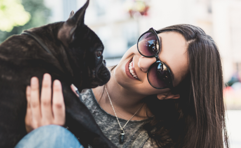 women with sunglasses holding dog at happy hour