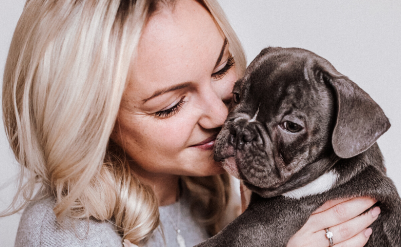 woman holding puppy caption reads "10 tips for socializing your puppy when you're stuck at home"