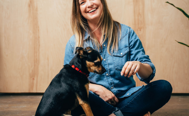 amy lynn sitting cross-legged and smiling with her black dog terry