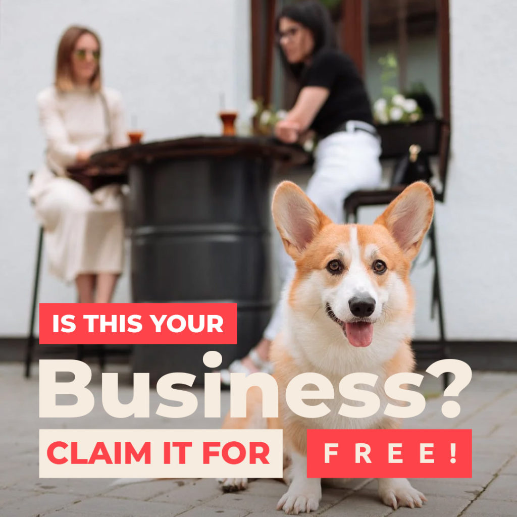 corgi dog sitting in foreground with two women sitting in background with wine glasses, overlay text reads "Is this your business? Claim it for free!"