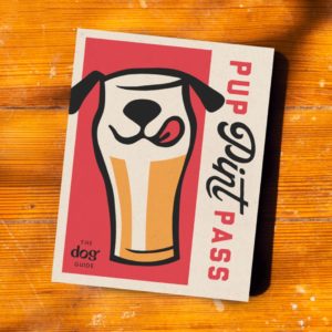 booklet on wood table with beer pint with dog ears mouth and tongue and combination script and block text that reads Pup Pint Pass